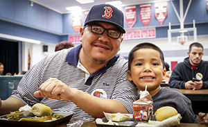 Father and young son eat lunch in the cafeteria